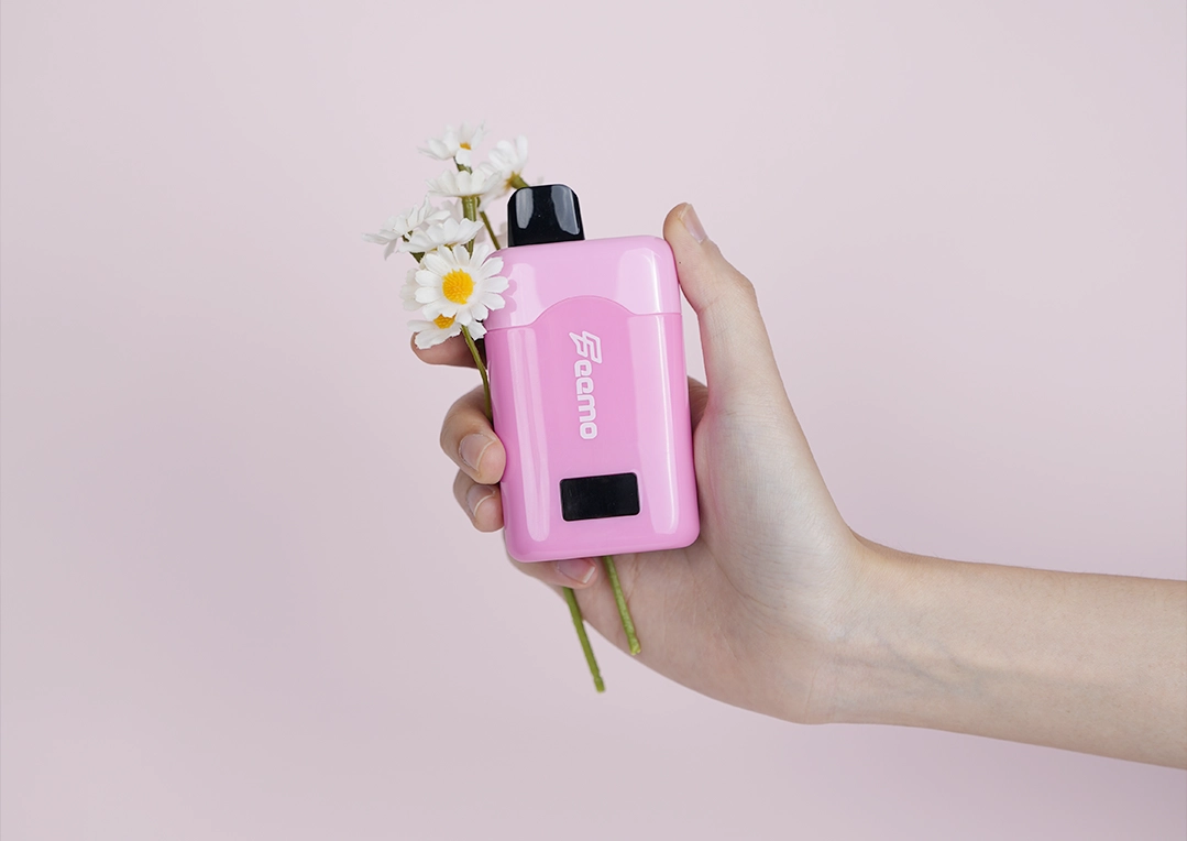 Hand holding pink disposable vape with flowers